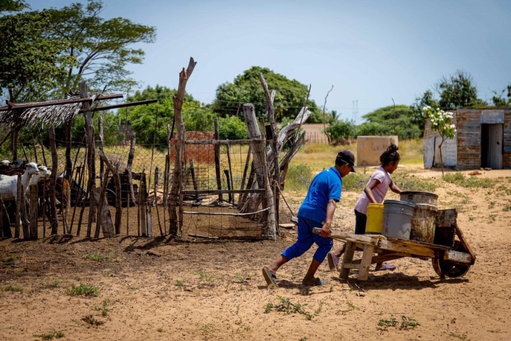 Dos niños transportan agua en una carretilla, en San Vicente de Mapuey (Venezuela). En la comunidad de San Vicente de Mapuey no hay "nada", o eso insisten en asegurar sus habitantes, de la etnia Wayú, para denunciar el "olvido" en que se encuentran. En este desértico lugar, lo que abunda son los reclamos de los pueblos indígenas, algunos de los cuales parecen desoídos durante generaciones en Venezuela